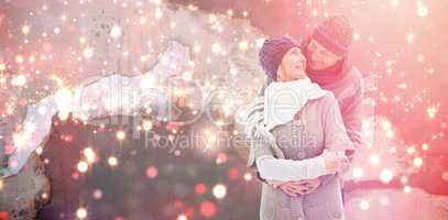 Composite image of happy mature couple in winter clothes embracing