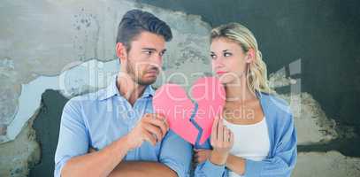 Composite image of couple holding two halves of broken heart