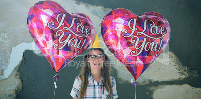 Composite image of geeky hipster holding balloons