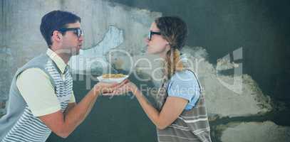 Composite image of geeky hipster couple holding pasta