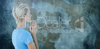 Composite image of pretty blond woman praying