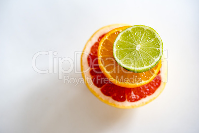 Colorful pile of half citrus fruit, top view, horizontal.