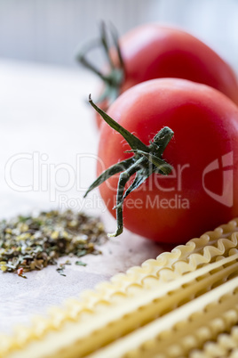 Dry spaghetti, fresh tomatoes and Italian herbs, macro.