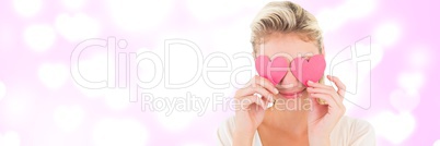 Valentines woman holding hearts over eyes with love hearts background