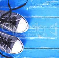 pair of blue textile shoes with loose white laces