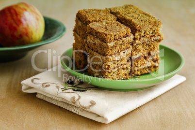 Cake and Apple on the table on a plate.