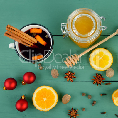 Hot red mulled wine on wooden background with spices, orange sli