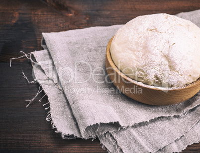 yeast dough in a wooden bowl