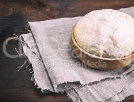 yeast dough in a wooden bowl