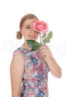 Woman standing in dress with rose on her face
