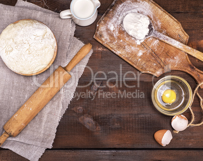 yeast dough in a wooden bowl, top view