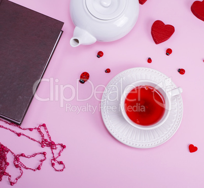 tea with berries of viburnum in a white ceramic cup with saucer