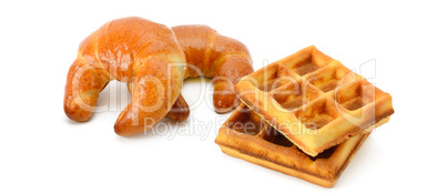 Croissants and waffles isolated on white background. Wide photo.