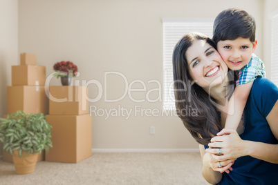 Young Mother and Son Inside Empty Room with Moving Boxes.