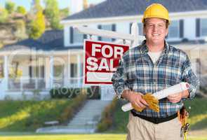 Contractor With Plans and Hard Hat In Front of For Sale Real Est