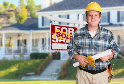 Contractor With Plans and Hard Hat In Front of Sold For Sale Rea