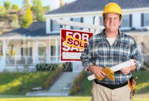 Contractor With Plans and Hard Hat In Front of Sold For Sale Rea