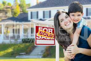 Young Mother and Son In Front of Sold For Sale Real Estate Sign