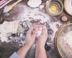 women's hands mix yeast dough from white wheat flour