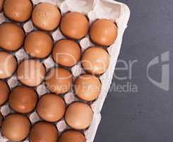 raw eggs in eggshell on paper tray