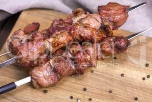 fried pieces of pork on skewers