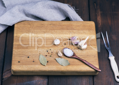 wooden cutting board with garlic and spoon of salt