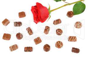 Assortment of chocolates and red rose isolated on white backgrou