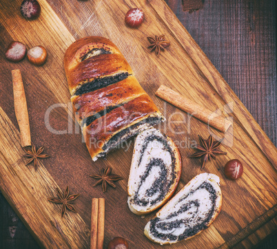 baked roll with poppy seeds on a wooden board