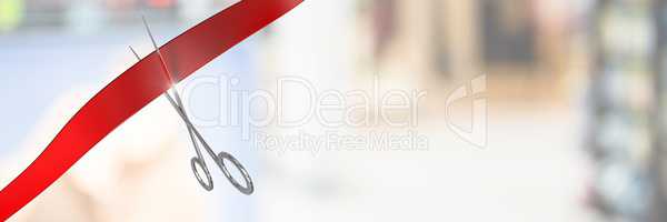 Scissors cutting ribbon with blurred background