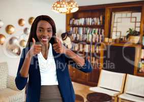 woman smiling in livingroom with thumbs up