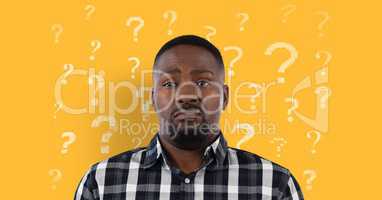 Confused or disgusted man in front of a yellow background with question marks pattern