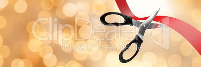 Scissors cutting ribbon with gold bokeh lights