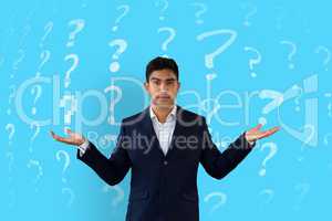Man shrugging in front of a blue background with question marks pattern