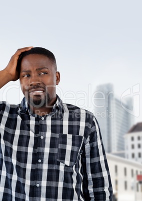 Confused man holding his head looking on the right in a city