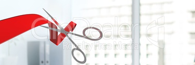 Scissors cutting ribbon with office windows of buildings