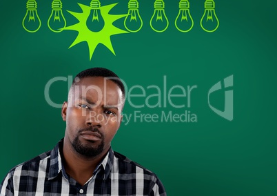 Confused man with bulbs on green background