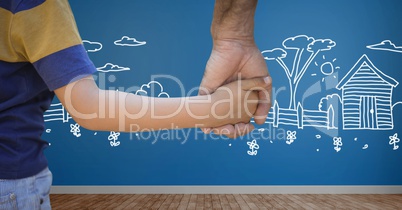 Boy holding adult hand with garden drawings on wall