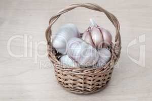 Garlic in a wicker basket on the table.