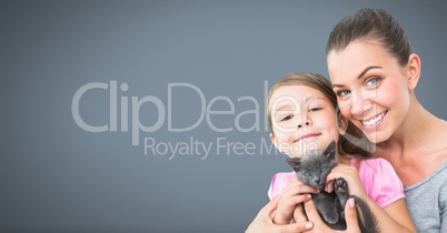 Mother and daughter holding cat with grey background