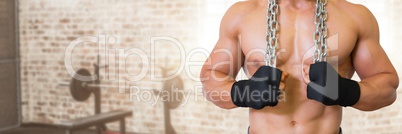 Fit strong Man in gym holding chains