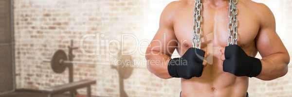 Fit strong Man in gym holding chains