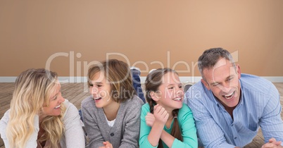 Family laughing together having fun with orange wall in room