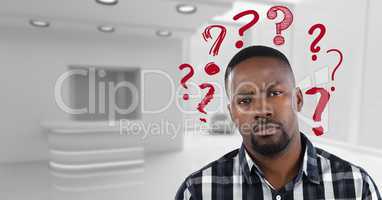 Confused man in a white office with red question marks