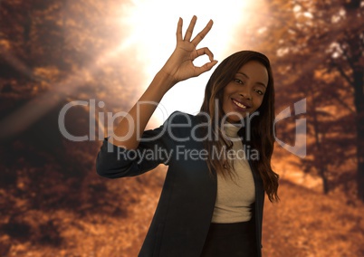 woman in forest smiling with ok sign