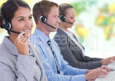 Travel agents wearing headsets in front of world map