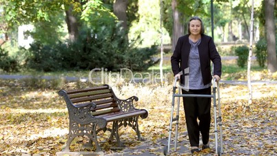 Senior woman with walker getting up and walking outdoors