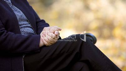 Senior woman rubbing her hands outdoors closeup