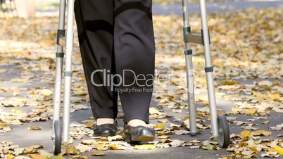 Senior woman legs walking with walker in autumn park