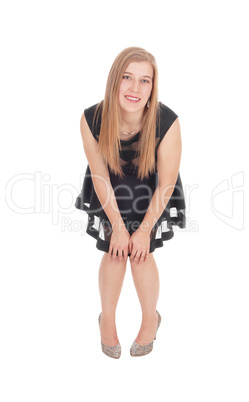 Happy woman in a short black dress bending