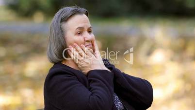 Depressed senior woman outdoors